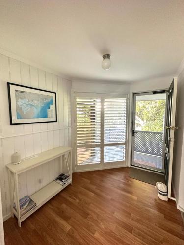 a living room with wooden floors and white walls at Water Front in Saint Margaret Island