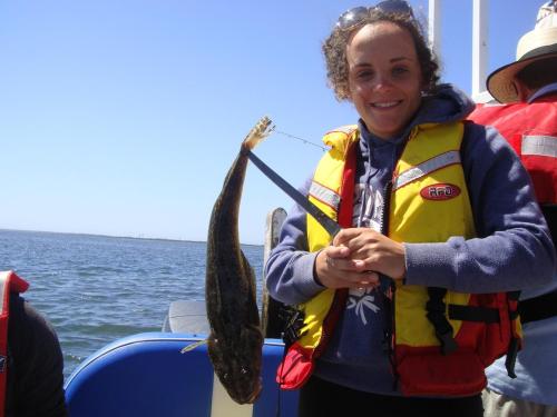 a woman holding a fish on a boat at Water Front in Saint Margaret Island