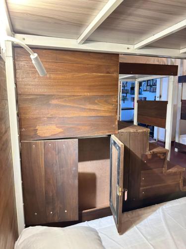 a bed with a wooden wall in a room at The Fort Library Hostel in Galle