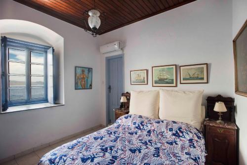 a bedroom with a bed and a window at Theodora's House in Hydra