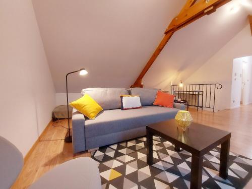 ein Wohnzimmer mit Sofa und Tisch in der Unterkunft Appartement cosy rénové près de Chartres - FR-1-581-147 in Le Boullay-Thierry