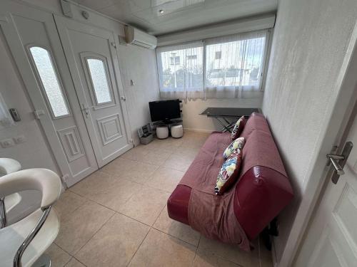 un salon avec un canapé et une télévision dans l'établissement Charmant 2 Pièces avec terrasse et jardin clos, parking inclus - FR-1-731-109, au Grau-du-Roi