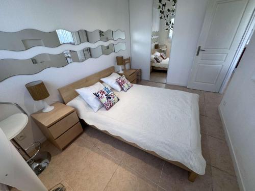 une chambre avec un lit avec des oreillers dessus dans l'établissement Charmant 2 Pièces avec terrasse et jardin clos, parking inclus - FR-1-731-109, au Grau-du-Roi