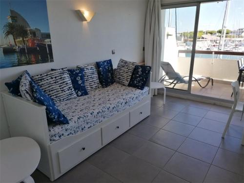 - une chambre avec un lit doté d'oreillers bleus et un balcon dans l'établissement Appartement 3 pièces pour 6 avec piscine, WIFI, et parking à Port Camargue - FR-1-731-108, au Grau-du-Roi