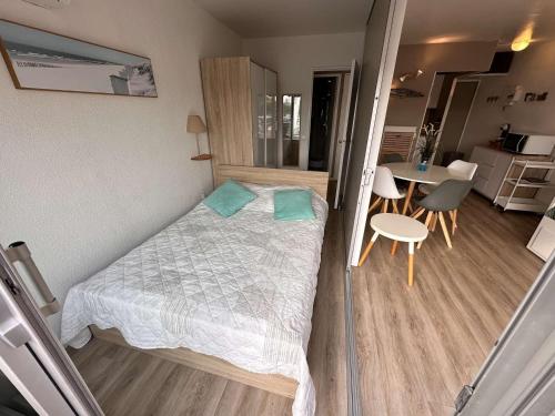 une petite chambre avec un lit et une table dans l'établissement Appartement 2 pièces climatisé avec parking, terrasse - Port Camargue - FR-1-731-110, au Grau-du-Roi