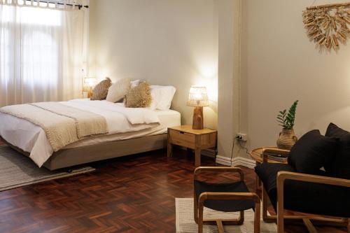 a bedroom with a bed and a living room at baan nuit Bangkok Stayhouse in Bangkok