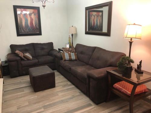 a living room with a brown couch and a table at Casa céntrica, confortable y equipada de 3 recamaras in Heroica Caborca