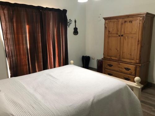 a bedroom with a bed and a wooden dresser at Casa céntrica, confortable y equipada de 3 recamaras in Heroica Caborca