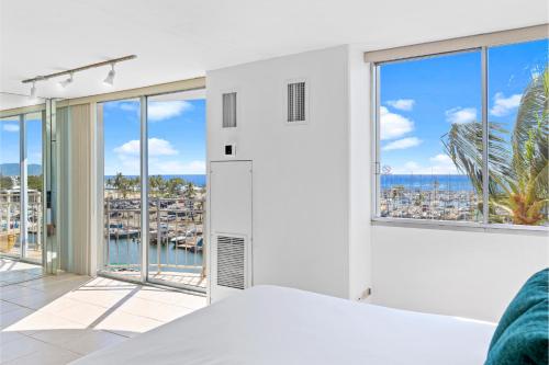a bedroom with white walls and large windows at Ilikai Marina 6FL Ocean View & Marina, Renovated in Honolulu