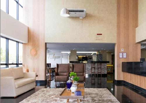 una sala de estar con un sofá y una mesa en Suíte em Cosmopolitan Home e Office em Palmas, en Palmas