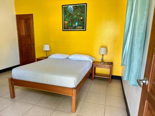 a bedroom with a bed and a yellow wall at Hospedaje Soma in Moyogalpa