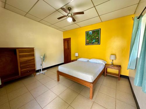 a bedroom with a bed and a yellow wall at Hospedaje Soma in Moyogalpa