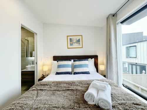 Un dormitorio con una cama grande con toallas. en City & Ponsonby Center Side 2 BDR Townhouse vs AC, en Auckland