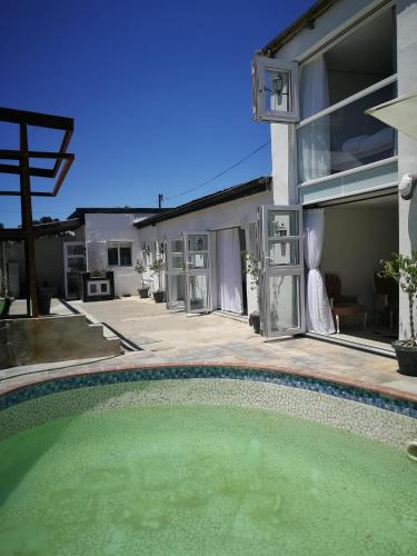 a swimming pool in front of a house at M Group B&B in King Williamʼs Town