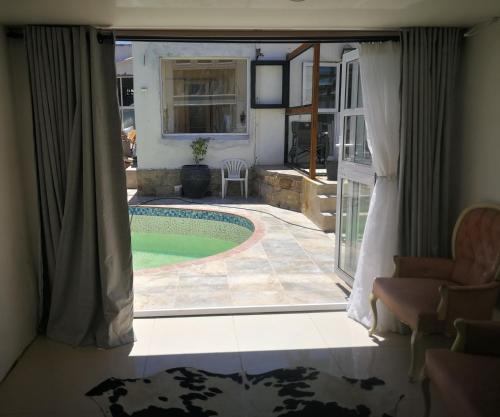 a view of a swimming pool through a window at M Group B&B in King Williamʼs Town