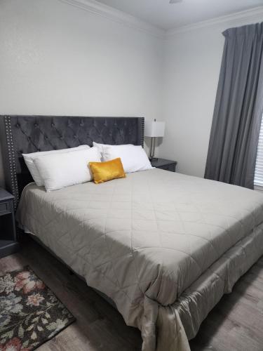 ein Schlafzimmer mit einem großen Bett und einem gelben Kissen in der Unterkunft Tuscana Resort Near Disney in Kissimmee