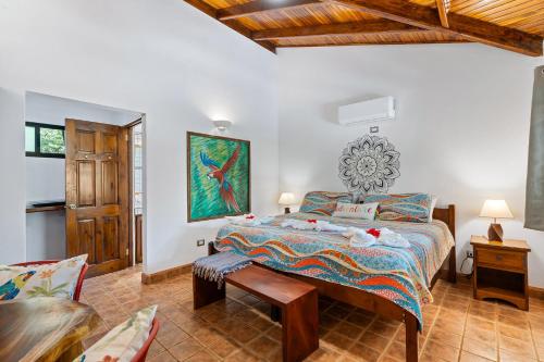 a bedroom with a large bed and a chair at Balu Retreat Center in Playa Junquillal