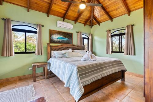 a bedroom with a bed in a room with windows at Balu Retreat Center in Playa Junquillal