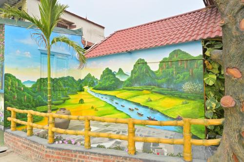 a mural on the side of a building with a palm tree at TamCoc Moon An Bungalow & Cafe in Ninh Binh
