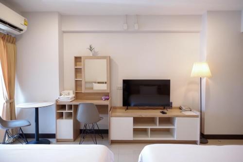 a bedroom with a desk with a television and a mirror at U Sabai Hotel Bangkok in Bangkok
