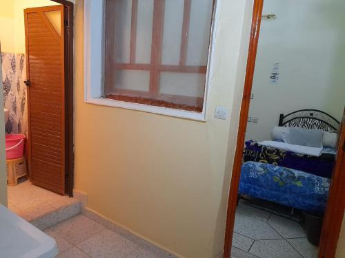 a room with a door and a window and a chair at Tata Guest House in Tatta