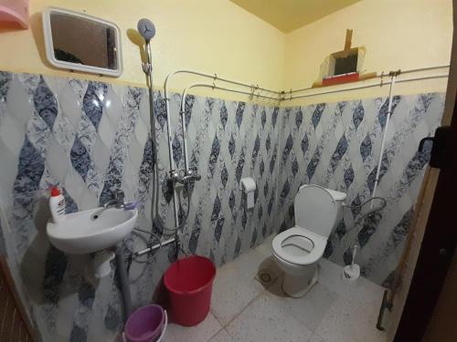 a bathroom with a toilet and a sink at Tata Guest House in Tatta