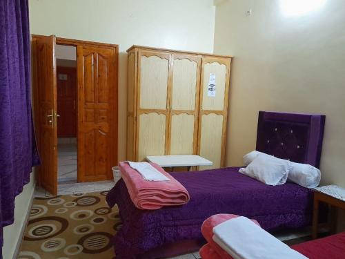 a bedroom with a bed and a table and a door at Tata Guest House in Tatta