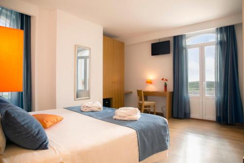 a hotel room with a bed with towels on it at Hotel Mira Sagres in Vila do Bispo