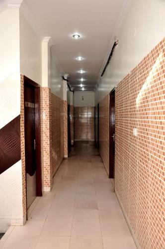 an empty corridor with red brick walls and a hallway with doors at Asha Guest House in Amritsar