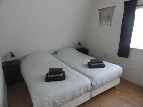 1 dormitorio con 2 camas y toallas. en Vakantiewoning Duinoord Domburg, en Domburg