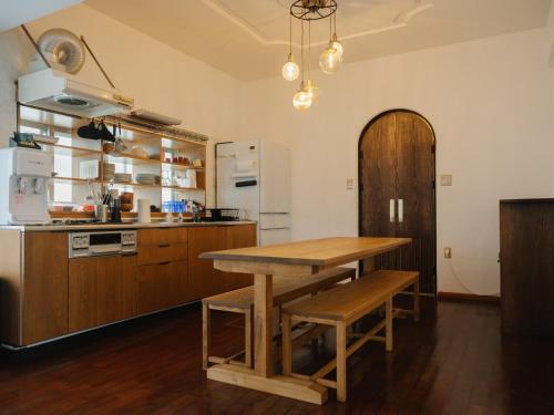a kitchen with a wooden table and a refrigerator at ASAHi in Ikei