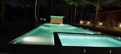 an empty swimming pool at night with lights at West Coast Gokarna in Gokarna
