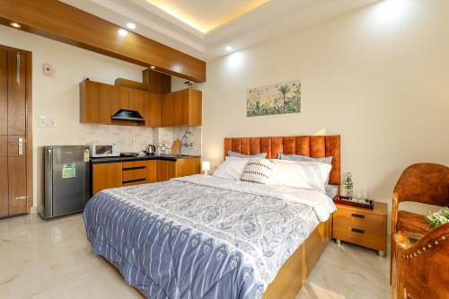 a bedroom with a large bed and a kitchen at zest living sector 55 in Gurgaon