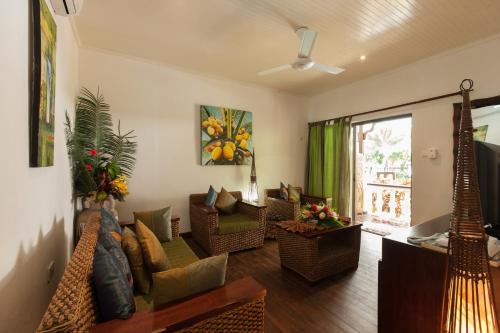 a living room with a couch and chairs at Le Relax Beach Resort in Grand'Anse Praslin