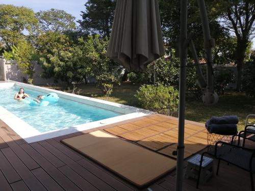 two people in a swimming pool with an umbrella at AP HOUSE in Bangkok