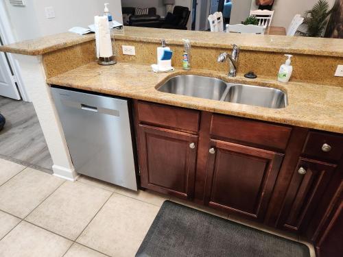 eine Küchentheke mit Spüle und Geschirrspüler in der Unterkunft Tuscana Resort Near Disney in Kissimmee