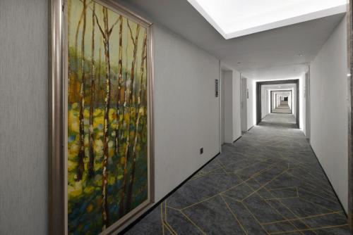 a hallway with a large painting on the wall at Home Inn Paibaiyun Hotel Chengdu Tianyu Road Subway Station Branch in Chengdu