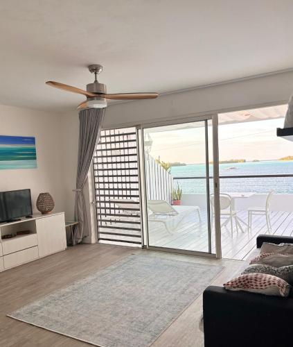 sala de estar con ventilador de techo y puerta corredera de cristal en Studio Deluxe, en Bora Bora