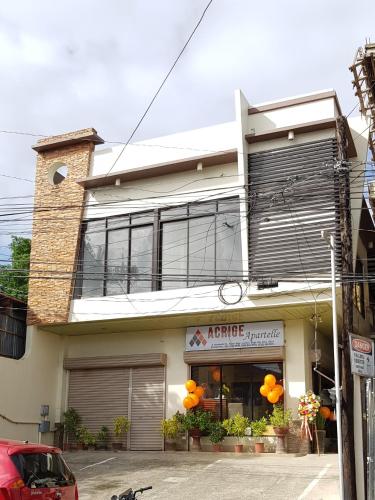 a building with orange balloons in front of it at Acrige Apartelle Studio Rooms at heart of Bogo City in Bogo
