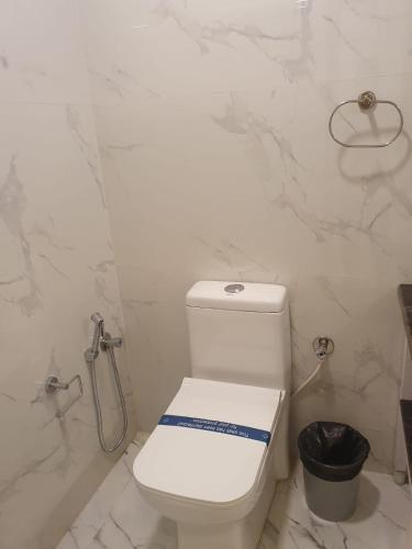 a white bathroom with a toilet and a shower at Peters Park in Yelagiri