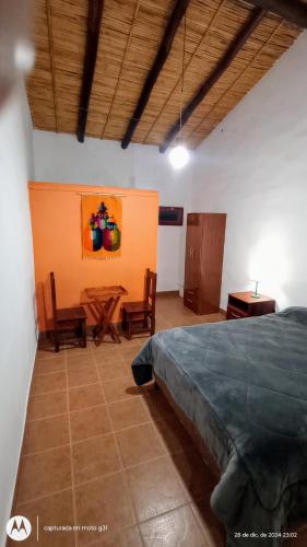 a bedroom with a bed and a table and chairs at Tampu 4 alojamiento in Purmamarca