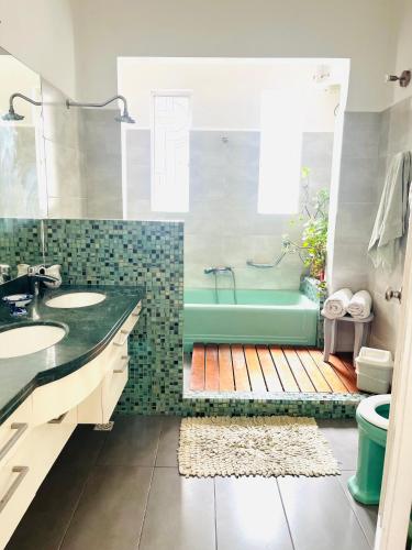 a bathroom with a green tub and a sink at en el corazón del Barrio Sur in Montevideo