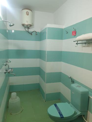 a bathroom with a blue and white striped wall at Peters Park in Yelagiri