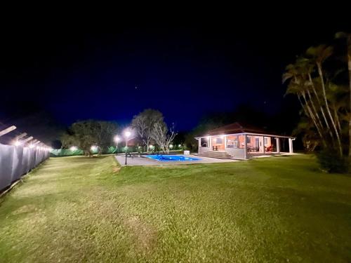 a house with a large yard at night at Country house with pool wifi and perfect view in Itapetininga