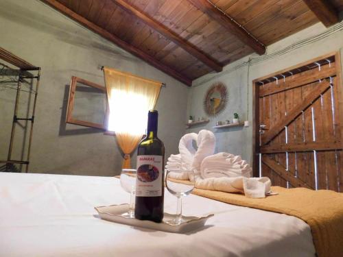 a bottle of wine sitting on a bed with a glass at Michaela's House in Tsikalariá