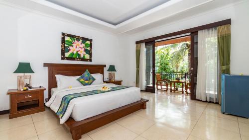 a bedroom with a bed and a balcony at Gita Maha Ubud Hotel by Mahaputra-CHSE Certified in Ubud