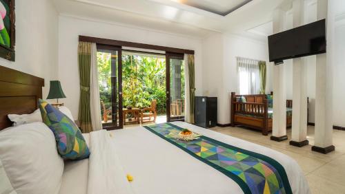 a bedroom with a large bed and a balcony at Gita Maha Ubud Hotel by Mahaputra-CHSE Certified in Ubud