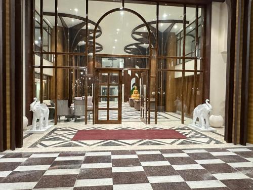 a lobby of a building with a red rug on the floor at Nirvana Grand Hotel & Resort in Gaya