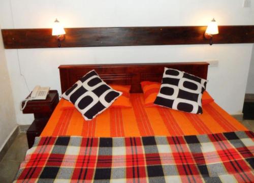a bed with two pillows on top of it at Travellers Halt in Ratnapura