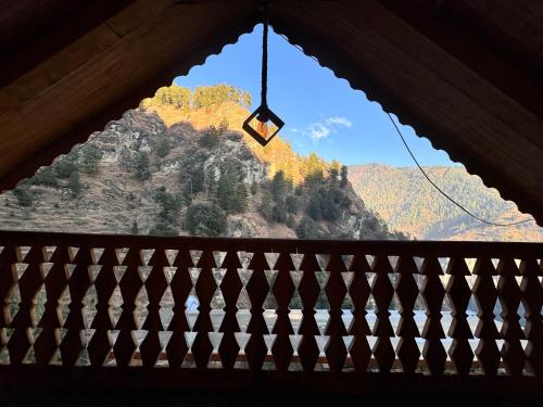 a view of a mountain from a wooden window at Laida Holiday Homestay in Banjār